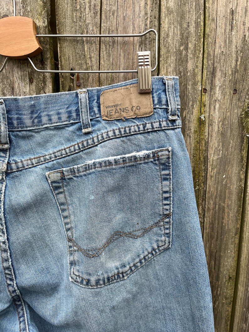 May include: A pair of light blue denim jeans with a back pocket and a brown leather patch that says "Wrangler Jeans Co."