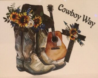 May include: Cowboy boots, a guitar, and a cross with sunflowers and blue flowers are arranged on a white background. The text "Cowboy Way" is written in black above the arrangement.