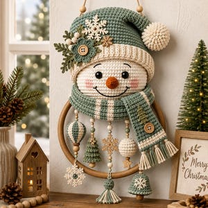 Puede incluir: Un adorno de pared de ganchillo con forma de muñeco de nieve, con un gorro verde salvia con pompón blanco, bufanda a juego y base de aro de madera. El muñeco está decorado con copos de nieve de madera, formas tejidas y cuentas colgantes.