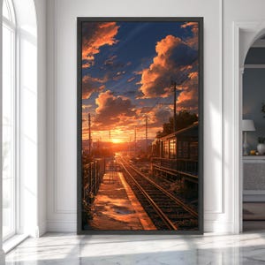 Pode incluir: Uma impressão de arte de parede vertical emoldurada retratando uma plataforma de estação de trem ao pôr do sol. A cena apresenta trilhos de trem que se estendem ao longe sob um céu laranja e azul vibrante com nuvens, ao lado de uma estação.