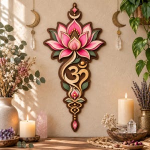 Könnte beinhalten: Ein vertikaler Wandbehang aus Holz mit einer geschichteten Lotusblüte in Rosa- und Grüntönen, platziert über einem goldenen Om-Symbol. Das Design umfasst komplizierte dekorative Schnörkel und spitze Akzente, eingefasst in einen dunklen Holzrahmen.