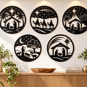 May include: Five circular black wall art pieces featuring intricate laser-cut silhouettes of nativity scenes, including the holy family, the three wise men on camels, a shepherd with sheep, and a star-filled night sky with a bright guiding star.