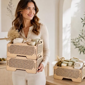 May include: Two stacked light-colored wooden crates with a diamond-patterned lattice design on the sides, filled with rolled white towels and dried flowers. A third matching wooden crate sits nearby, also containing rolled towels and small items.