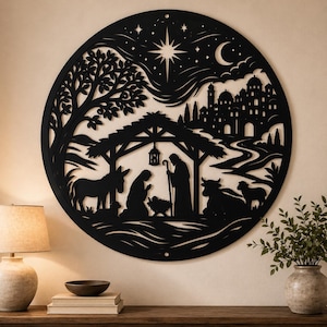 Könnte beinhalten: Ein kreisförmiges, schwarzes Wandkunstobjekt mit einer detaillierten Krippenszene als Silhouette. Das Design zeigt einen Stall mit Figuren, einen Esel, eine Kuh, ein Schaf, einen Baum, eine Stadt im Hintergrund, eine Mondsichel und einen großen Stern.