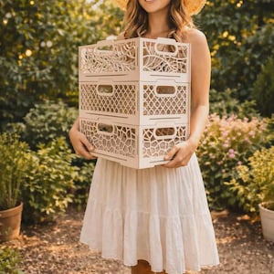 May include: A stack of three light-colored rectangular storage crates with intricate laser-cut patterns on the sides. Each crate features integrated handles and a distinct geometric design, including organic branch-like and grid-style motifs.