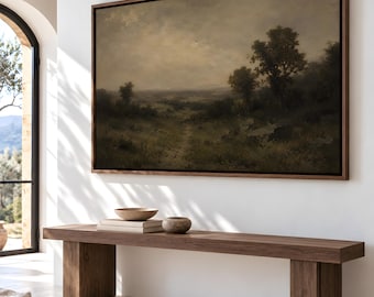 May include: A large rectangular landscape painting in a dark wood frame, depicting a moody, overcast field with scattered trees and a dirt path, mounted on a white wall above a long, solid dark wood bench with block legs.