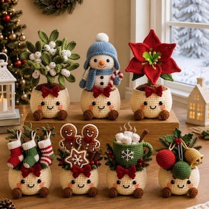 Op de afbeelding: Een verzameling van zeven kleine, crèmekleurige gehaakte potjes met lachende gezichtjes, elk met een ander vakantie-thema, waaronder maretak, een sneeuwpop, een kerstster, kerstsokken, peperkoekmannetjes, een mok en kerstversieringen.