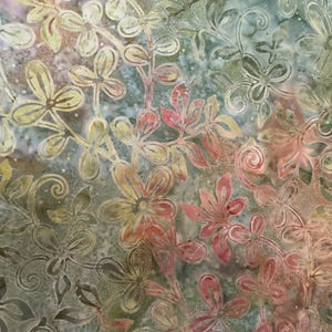 May include: A green, red, and yellow floral fabric with a batik pattern. The fabric features a repeating design of stylized flowers and leaves.