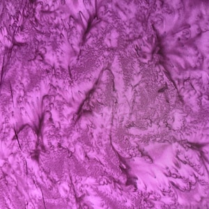 May include: Purple fabric with a marbled, tie-dye pattern. The fabric has a soft, flowing texture.