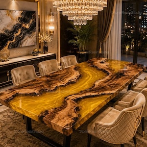 May include: A rectangular dining table featuring a live edge wood slab with a central translucent amber resin river design, supported by black metal legs. The table is surrounded by six beige upholstered chairs with quilted back detailing.