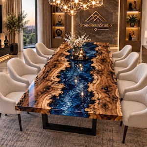 May include: A large rectangular dining table featuring a live edge wood slab with a central river of deep blue resin. The table is supported by a black metal base and surrounded by ten cream-colored upholstered chairs with dark wooden legs.
