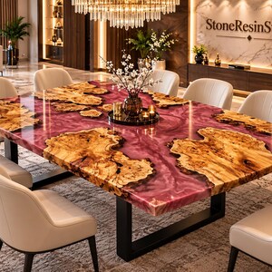 Op de afbeelding: Een rechthoekige eettafel met een houten blad met natuurlijke randen en houtnerven, ingebed in een glanzend, diepmagenta hars oppervlak. De tafel wordt ondersteund door een zwart metalen frame en is omringd door acht crèmekleurige stoelen.