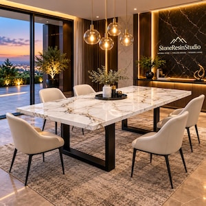 Op de afbeelding: Een rechthoekige eettafel met een wit marmeren blad met donkere aders en een zwart metalen onderstel, omringd door vier beige gestoffeerde stoelen met zwarte poten. Het StoneResinStudio-logo is zichtbaar op de donkere marmeren muur erachter.