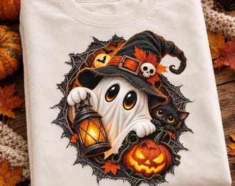 Può includere: Una felpa color crema con la grafica di un fantasma bianco che indossa un cappello da strega nero con un teschio e foglie d'acero arancioni. Il fantasma tiene una lanterna accesa accanto a un gatto nero e una zucca illuminata, incorniciati da una ragnatela.