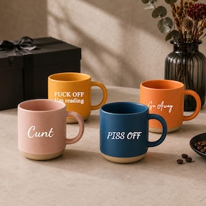May include: A set of four ceramic mugs in pink, yellow, blue, and orange, each with a contrasting beige base. The pink mug says Cunt, the yellow says FUCK OFF I'm reading, the blue says PISS OFF, and the orange mug features the text Go Away.