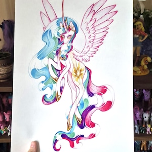 Puede incluir: Una impresión en papel blanco con una colorida ilustración de un unicornio alado con una larga melena y cola fluidas en tonos azul, rosa y morado. El unicornio tiene un cuerno dorado, una corona dorada y un emblema de sol dorado en el flanco.