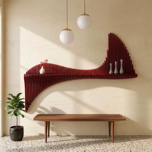 May include: A dark red, wave-shaped wall shelf with vertical slats, holding a small white vase and three slender white vases. Below the shelf sits a rectangular wooden bench with four legs, and a green potted plant stands to the left.