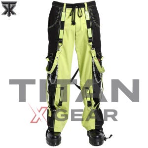 May include: Black and lime green cargo pants featuring a drawstring waist, vertical color-blocked panels, and decorative straps with silver-toned metal chains and D-ring hardware. The pants include side cargo pockets and black platform boots.