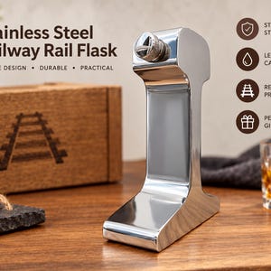 Könnte beinhalten: Ein polierter Edelstahlflachmann in Form eines Eisenbahnschienenprofils. Der Flachmann verfügt über einen strukturierten Schraubverschluss. Der Text auf dem Bild lautet: Stainless Steel Railway Rail Flask, Unique Design, Durable, Practical, Stainless Steel, Leak-Proof Cap, Real Rail Profile Shape, Perfect Gift.