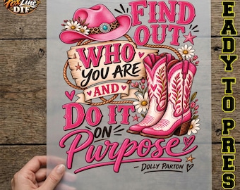May include: A graphic transfer sheet featuring a pink cowboy hat with white flowers, a pair of pink and white cowboy boots, and the text "FIND OUT WHO YOU ARE AND DO IT ON PURPOSE - DOLLY PARTON" surrounded by small hearts, stars, and daisies.