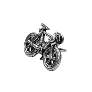 May include: A silver-toned metal bicycle charm with detailed wheels and handlebars.