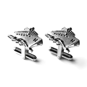 Può includere: Un paio di gemelli d'argento con un design dettagliato di una nave da crociera. I gemelli hanno uno stile classico ed elegante.