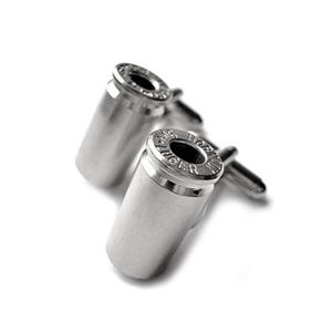 Może przedstawiać: Para srebrnych spinek do mankietów w kształcie pocisków. Spinki do mankietów mają cylindryczny korpus i szczegółową obręcz. Unikalny dodatek do formalnego stroju.