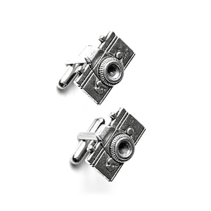 May include: A pair of silver camera cufflinks. The cufflinks are detailed with a vintage camera design.