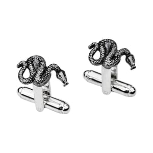 May include: A pair of silver cufflinks with a black snake design. The snakes are coiled and have a textured surface.