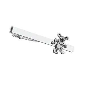 May include: Silver tie bar with a dancing bear charm. The bear is silver and has a smiling face.