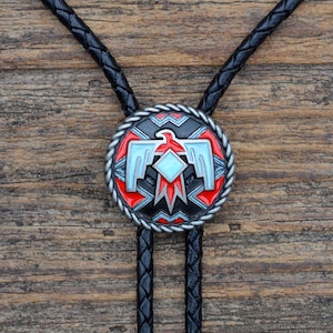Könnte beinhalten: Ein schwarzer Bolo-Krawattenhalter mit einem Bolo-Krawattenhalter aus Silber und Emaille mit einem indianischen Design mit einem roten, blauen und weißen Adler.