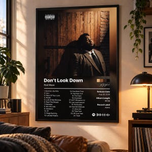 May include: A framed wall poster featuring the album cover for Don't Look Down by Rod Wave. The design includes a portrait of a person in a suit against a wooden background, a tracklist of 24 songs, release date, and a Spotify code graphic.