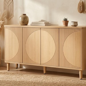 Könnte beinhalten: Ein Sideboard aus hellem Holz mit vier Schranktüren, die vertikale Rillen und große kreisförmige Schnitzereien aufweisen. Das rechteckige Aufbewahrungsmöbel steht auf vier zylindrischen Beinen und hat eine glatte, flache Oberfläche.