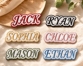 May include: Six rectangular embroidered name patches with scalloped edges. The patches feature the names JACK in red, RYAN in black, SOPHIA in gold, CHLOE in pink, MASON in green, and ETHAN in blue. Each name is stitched in a bold, cursive font.