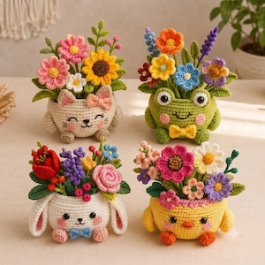 Può includere: Quattro vasi all'uncinetto a forma di animale contenenti fiori di lana colorati. Il set include un gatto color crema, una rana verde, un coniglio bianco e un pulcino giallo, ognuno con dettagli del viso ricamati e vivaci composizioni floreali.