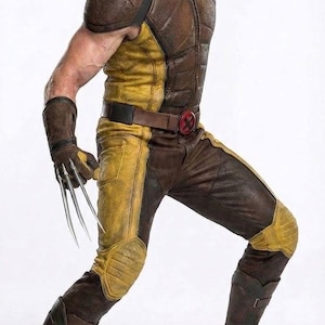 Puede incluir: Un traje táctico texturizado en marrón y amarillo que incluye un chaleco sin mangas, pantalones a juego y botas de color marrón oscuro. El conjunto cuenta con guantes con tres garras metálicas plateadas largas y afiladas y una hebilla roja.