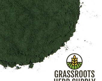 May include: A close-up of a pile of dark green spirulina powder. The powder is finely ground and has a smooth texture. The powder is a popular dietary supplement.