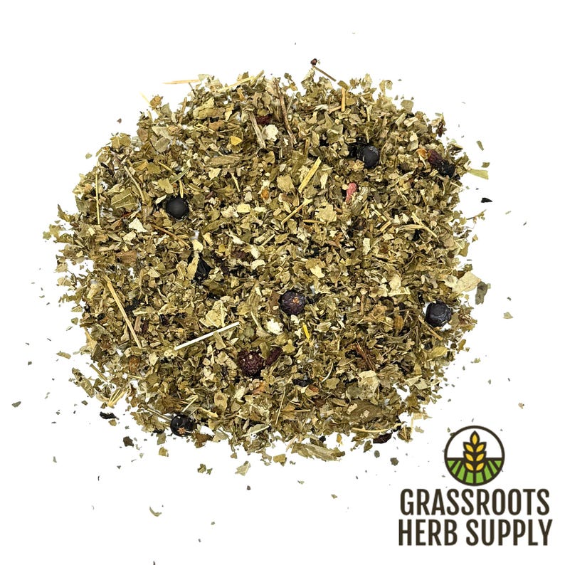 May include: A close-up of a pile of dried herbs and berries, including juniper berries, for making herbal tea. The herbs are a mix of green and brown, and the berries are dark blue. The image is labeled "Grassroots Herb Supply".