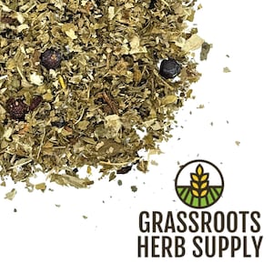 May include: A close-up of a pile of dried herbs and berries, including juniper berries, rose hips, and other botanicals. The herbs are a mix of green, brown, and red colors. The image is labeled "GRASSROOTS HERB SUPPLY".