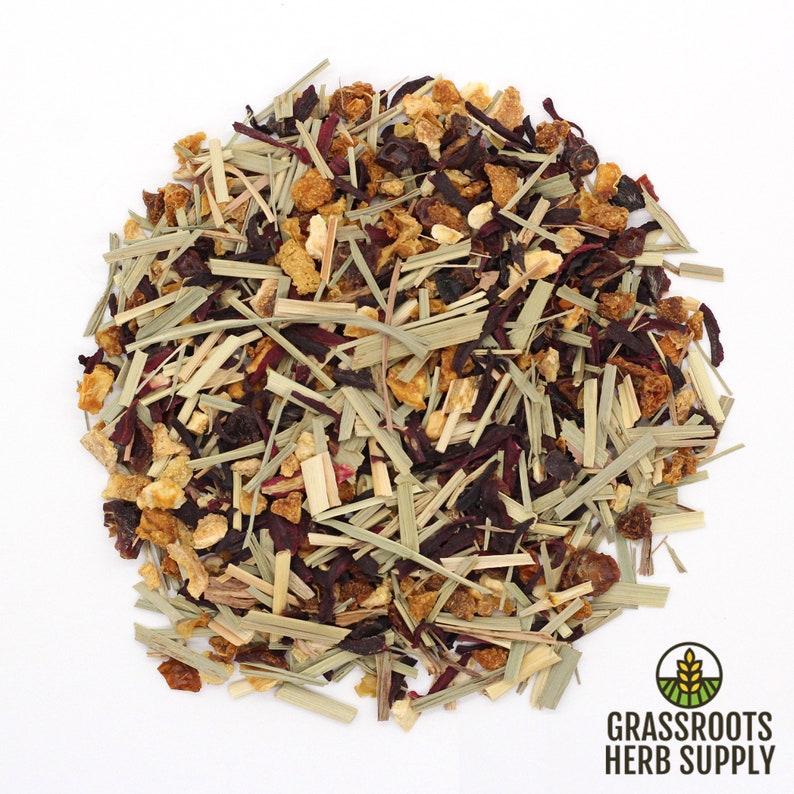 Puede incluir: Primer plano de una mezcla de hierbas y frutas secas, incluyendo hibisco, hierba de lim&oacute;n, c&aacute;scara de naranja y bayas. La mezcla es de un color rojo, naranja y verde vibrante.