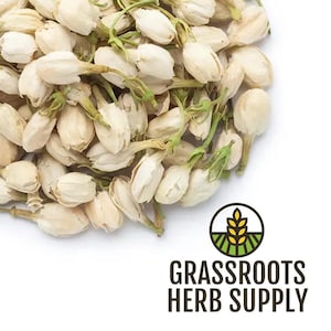 May include: Close-up of dried jasmine buds, ivory-colored with green stems, filling the frame. The buds are clustered together, with a few scattered around. The logo for Grassroots Herb Supply is in the lower right corner.