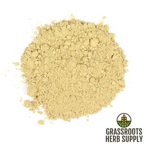 May include: A close-up of a pile of light brown ginger powder. The powder is finely ground and has a slightly grainy texture.