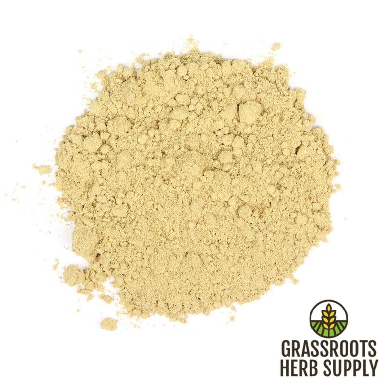 May include: A close-up of a pile of light brown ginger powder. The powder is finely ground and has a slightly grainy texture.
