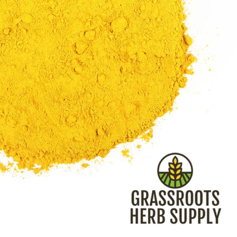 May include: A close-up of a pile of bright yellow turmeric powder. The powder is finely ground and has a smooth texture.