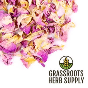 May include: Dried pink and yellow flower petals. The petals are loose and scattered on a white background. The image is labeled "GRASSROOTS HERB SUPPLY".