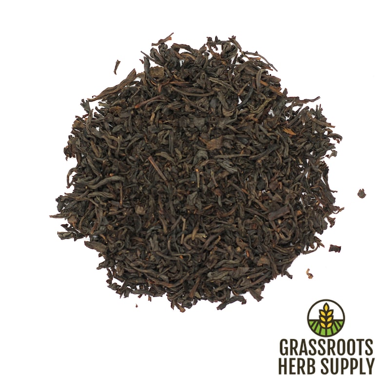 May include: Loose black tea leaves, a pile of dried tea leaves, ready to be brewed for a hot cup of tea.