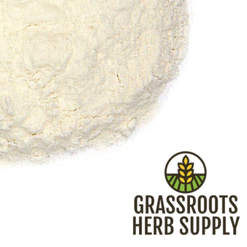May include: A close-up of a pile of white powder. The powder is a light beige color and has a fine texture. The powder is likely a type of flour or starch.