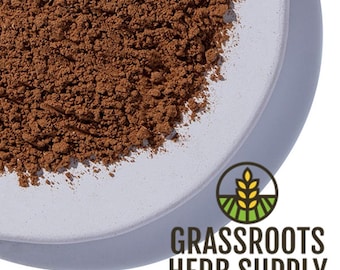 Puede incluir: Primer plano de un plato de cerámica gris claro lleno de polvo marrón finamente molido. El plato es parcialmente visible, con el logotipo "Grassroots Herb Supply" en la esquina inferior derecha.