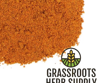 Puede incluir: Primer plano de un montón de especias finamente molidas, de color marrón rojizo. La imagen presenta el texto "GRASSROOTS HERB SUPPLY" debajo de un logotipo de una espiga de trigo y un campo verde. La especia parece ser una mezcla de hierbas y especias.
