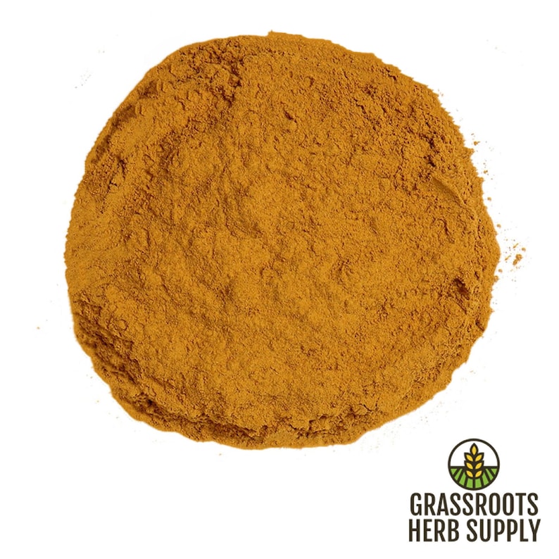 Puede incluir: Primer plano de un mont&oacute;n de polvo de c&uacute;rcuma molida, de un color amarillo-naranja brillante. El polvo tiene forma redonda y la textura es fina y suave.